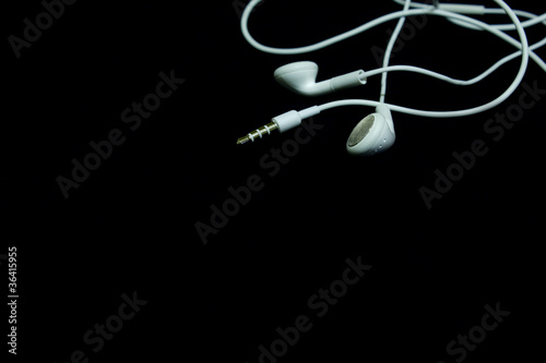 Photo: Earphones on a black background Earphones on a black background