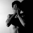 Portrait of a young man covering his face in hands