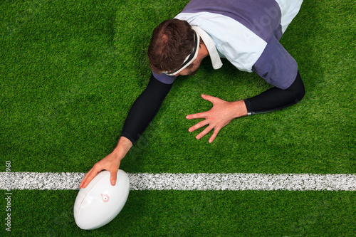 Photo: Rugby player scoring a try with one hand on the ball Rugby player scoring a try with one hand on the ball