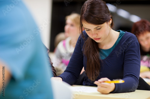 Photo: pretty, female college student sitting in a classroom pretty, female college student sitting in a classroom