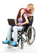 invalid girl on the wheelchair with laptop and friend