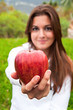 Foto: Young girl showing a red apple Young girl showing a red apple