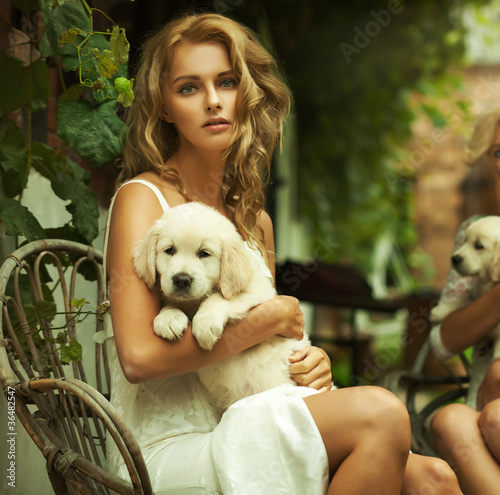 Foto: Portrait of a young blonde hugging a cute puppy Portrait of a young blonde hugging a cute puppy