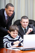 Kid boy explains multi ethnic business team how to work