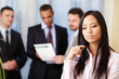 young pensive asian woman with her business partners