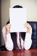 The new worker holds the blank paper in front of her face