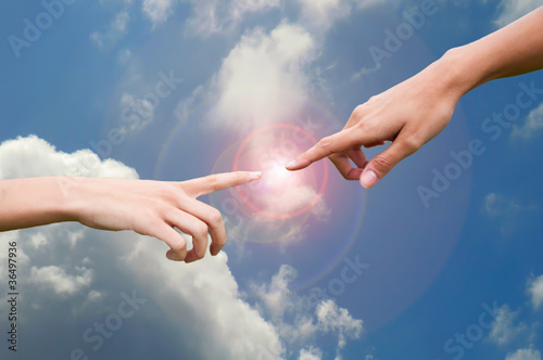 Photo: Fingers reaching to touch in a sky background Fingers reaching to touch in a sky background