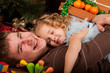 Little girl play with her dad  near Christmas tree