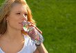 Attraktive Frau trinkt Wasser aus einer Flasche