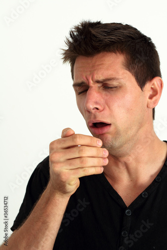 Photo: Sick man coughing into he's hand Sick man coughing into he's hand