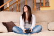 Photo: Young female lose playing video-games concentrating at home Young female lose playing video-games concentrating at home