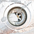 Detergent or soap bubbles and water going down the sink