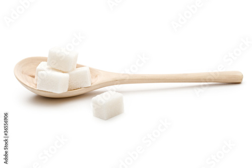 Photo: Sugar in a wooden spoon on the white background Sugar in a wooden spoon on the white background