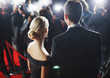 Celebrities posing for paparazzi on red carpet