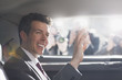 Politician waving from backseat of car