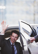 Politician waving and emerging from car