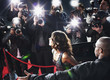 Celebrity emerging from car towards paparazzi