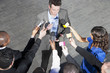 Politician talking into reporters' microphones