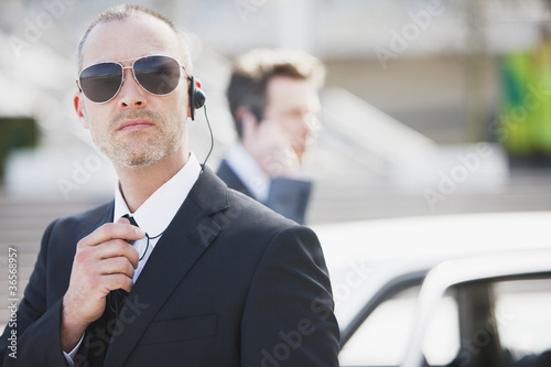 Photo: Bodyguard talking into earpiece Bodyguard talking into earpiece