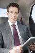 Politician sitting in backseat of car