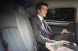Politician sitting in backseat of car