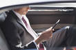 Politician reading in backseat of car