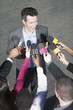 Politician talking into reporters' microphones