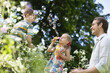 Family playing with bubbles outdoors