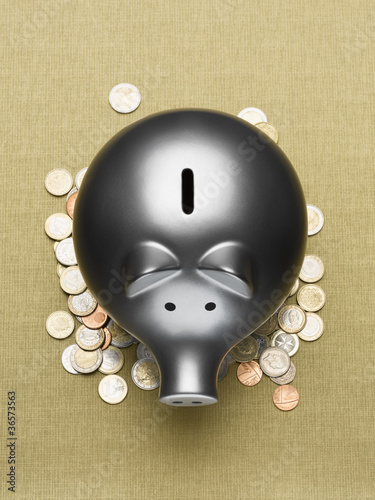 Photo: Piggy bank sitting on pile of coins Piggy bank sitting on pile of coins