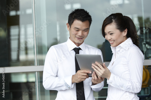 Photo: Asian business people using touch-pad tablet Asian business people using touch-pad tablet