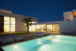Pool outside modern house at night