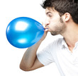 man blowing balloon