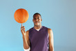 Basketball player balancing ball on one finger