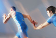 Blurred view of athletes passing baton