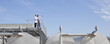 Scientists standing on walkway on tanks