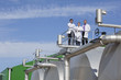 Scientists standing on walkway on tanks