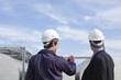 Worker and businessman examining tanks outdoors