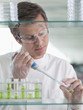 Scientist putting liquid in test tube in lab