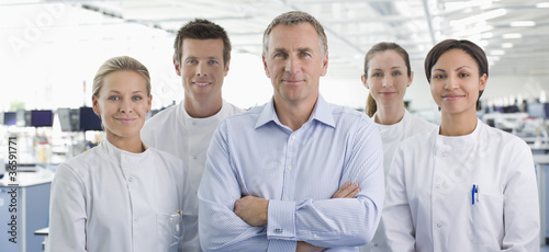 Photo: Scientists and businessman smiling in lab Scientists and businessman smiling in lab