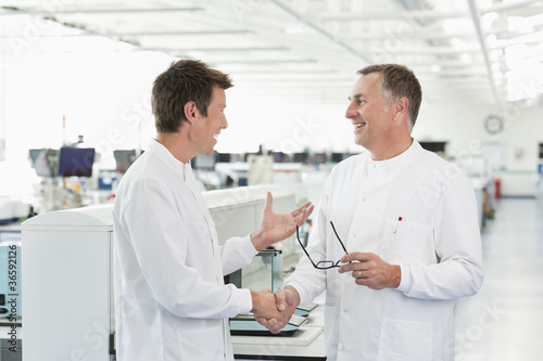 Foto: Scientists shaking hands in lab Scientists shaking hands in lab