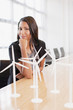 Foto: Businesswoman with wind turbine models in office Businesswoman with wind turbine models in office