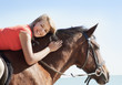 Girl petting horse on beach