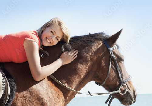 Photo: Girl petting horse on beach Girl petting horse on beach