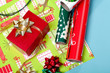 Red box with a gold bow and wrapping paper in the background Red box with a gold bow and wrapping paper in the background