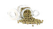 Green peppercorns spilling out of its spice jar