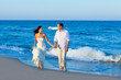 Mediterranean couple walking in blue beach