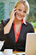 Photo: Junge Frau am Laptop telefoniert Junge Frau am Laptop telefoniert