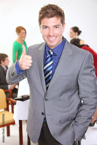 Photo: Young businessman gesturing thumbs up sign Young businessman gesturing thumbs up sign