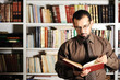 Young man reading book in library