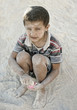 Portrait of poverty, little poor dirty boy playing in sand Portrait of poverty, little poor dirty boy playing in sand